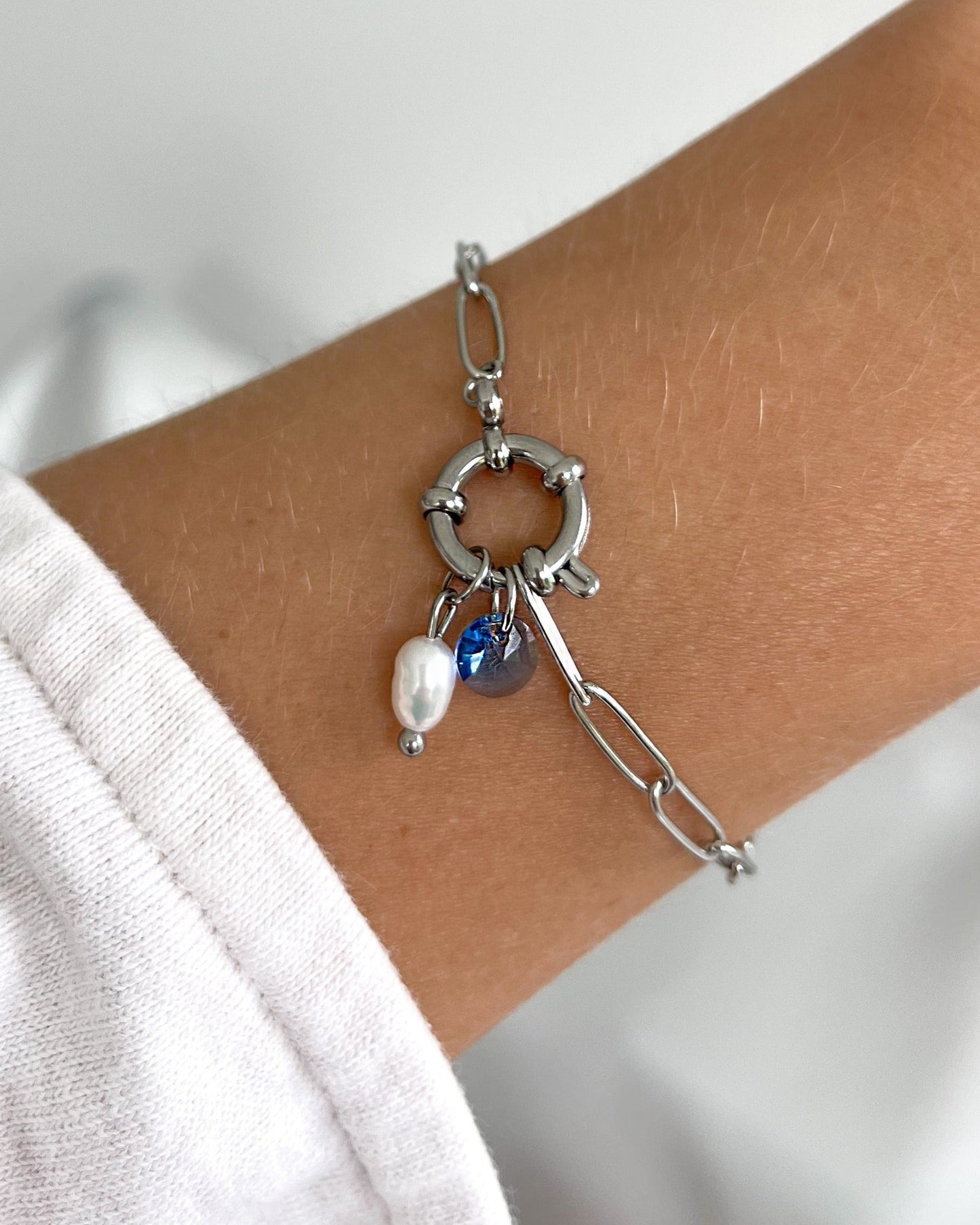 Geschliffener Glas Tropfen in blau an silbernem Armband.