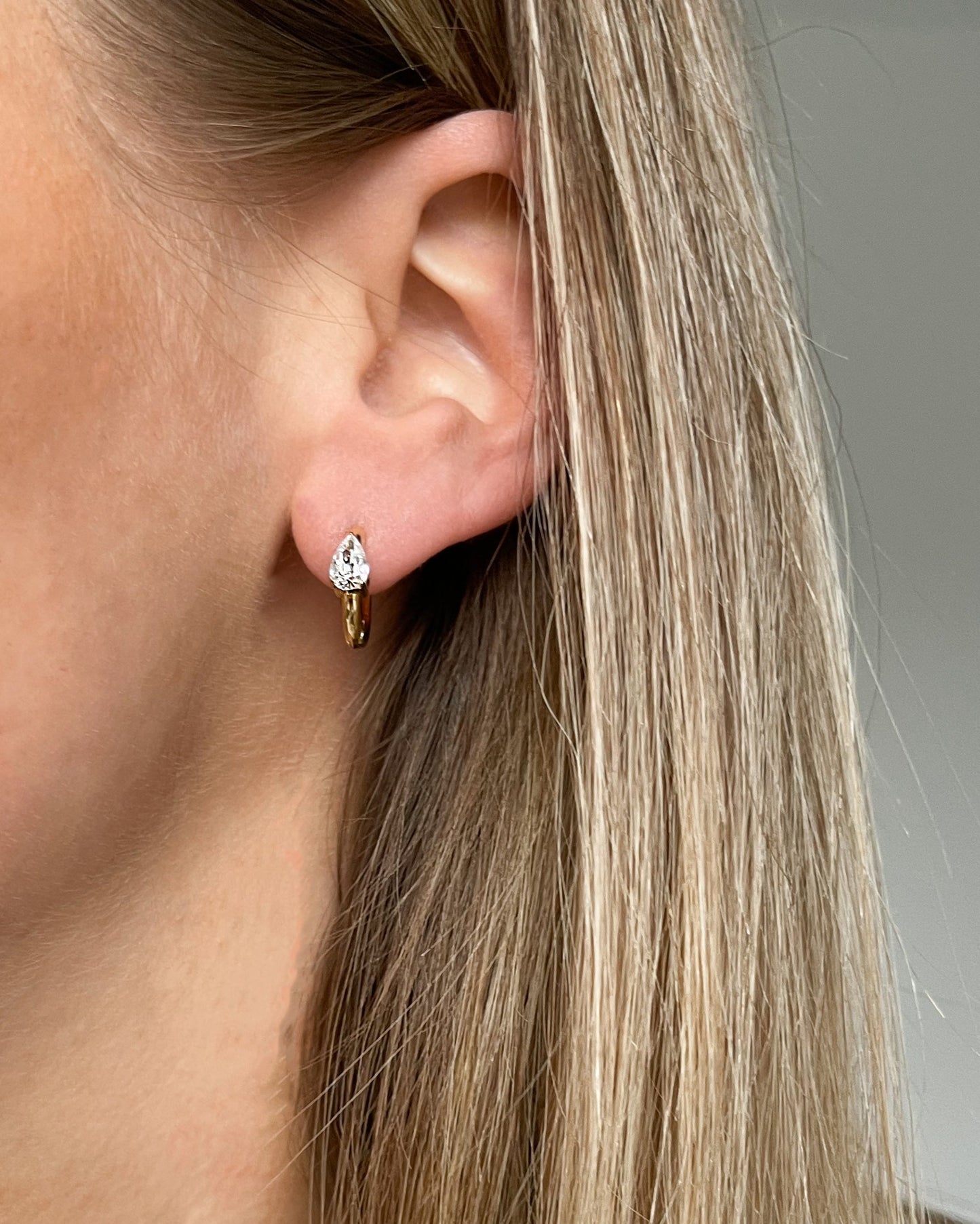 Süße Ohrringe mit Tropfen-Design aus Zirkonia Steinen in gold, getragen.