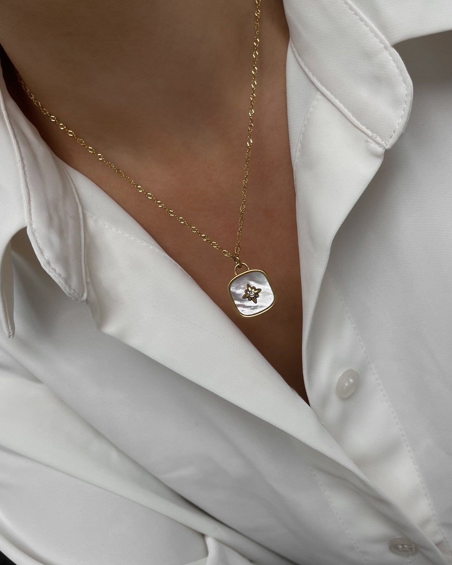 18k Vergoldete Edelstahlkette mit Perlmutt Design Anhänger, getragen mit einer weißen Bluse.