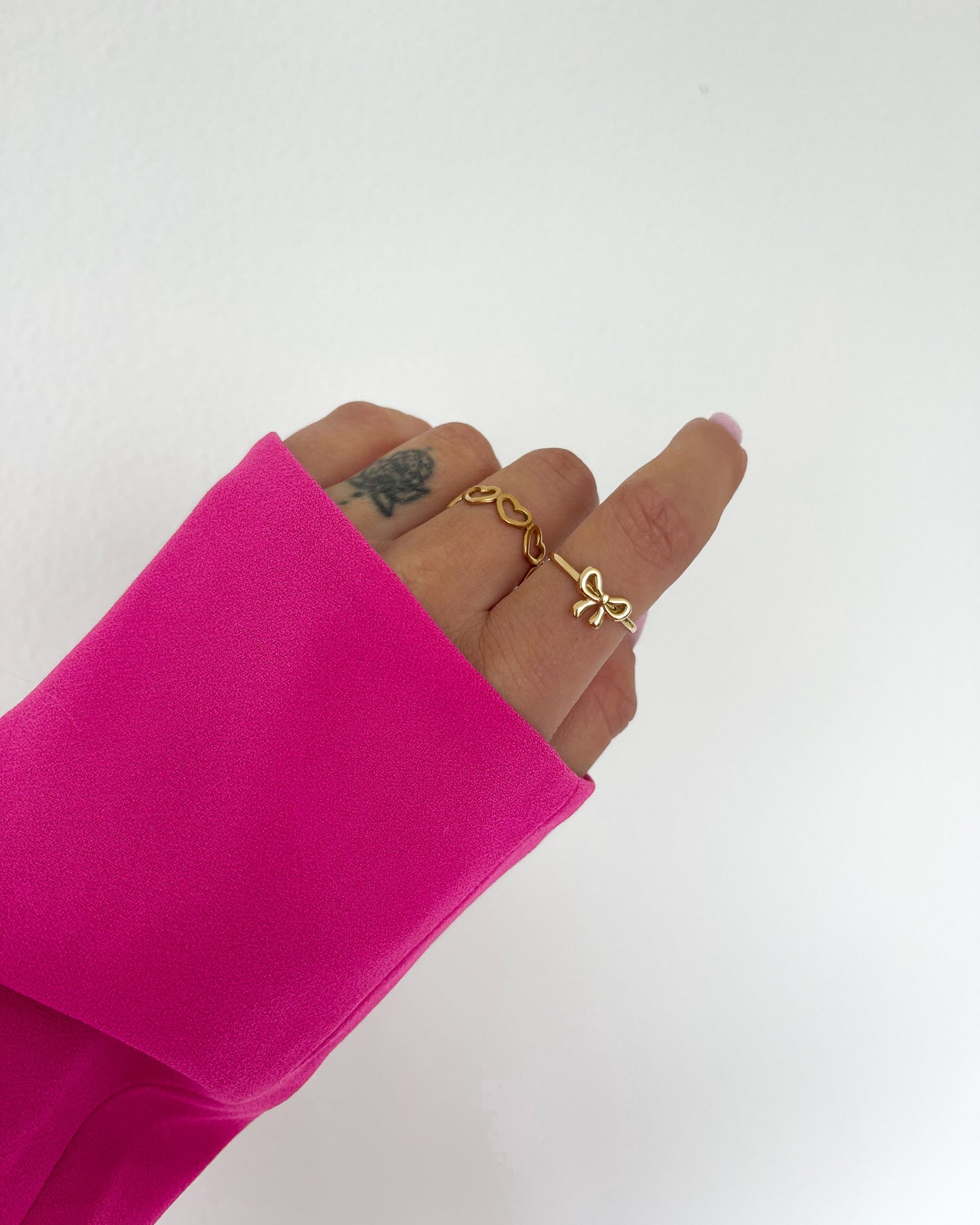 Verspielter Schleifenring, verstellbar in gold am Finger.