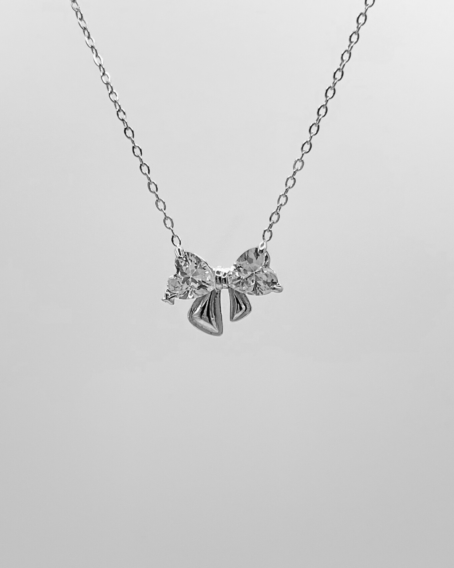Edelstahl Halskette mit Schleifen Design in silber mit Herzförmigen Zirkonia Steinen. Wasserfest und hypoallergen.