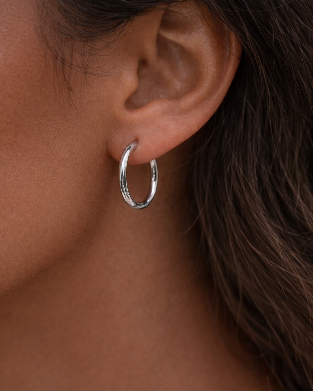 Silberne Creolen 2,5cm aus Edelstahl an Modell.