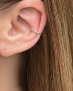 Feiner gedrehter Edelstahl Earcuff in silber getragen am Ohr.
