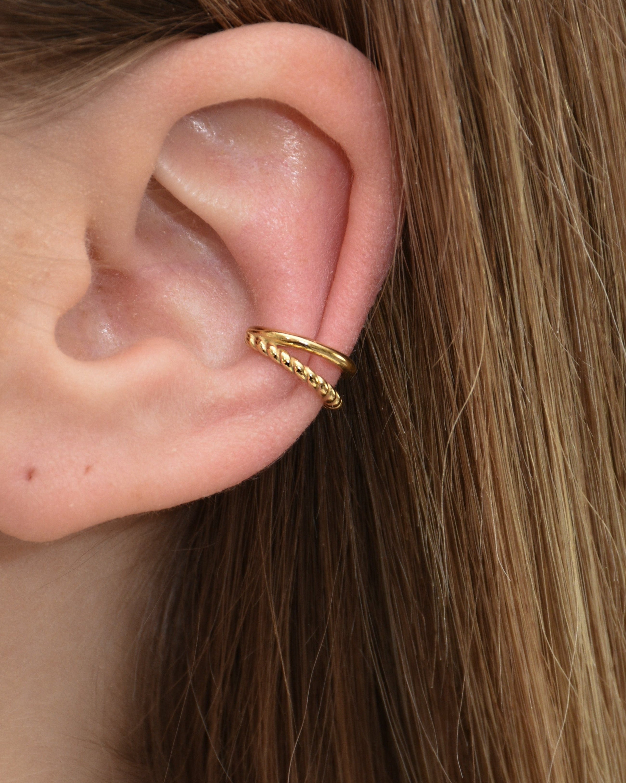 Doppellagiger Earcuff in gold getragen am Ohr.