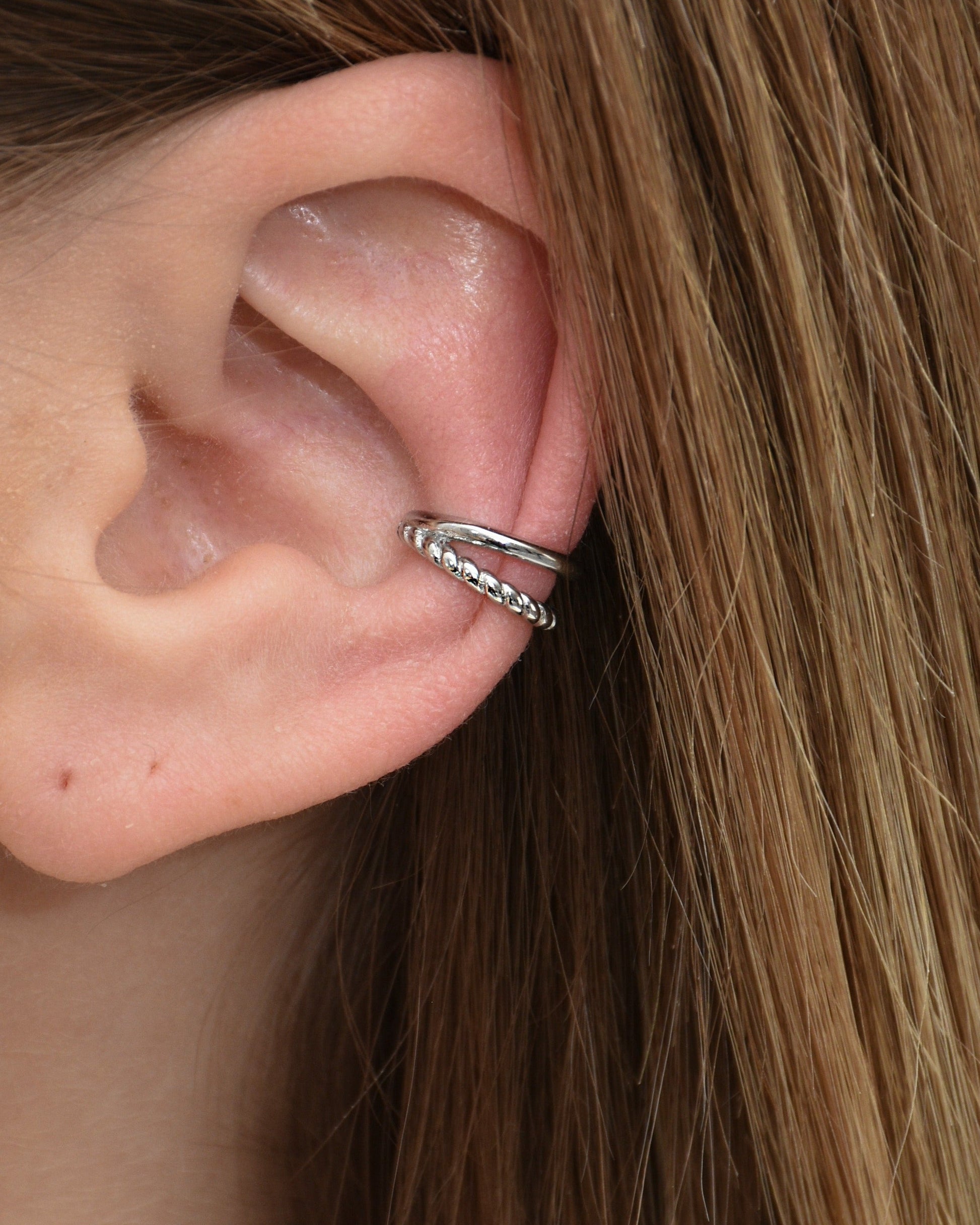 Doppellagiger Earcuff in silber getragen am Ohr.