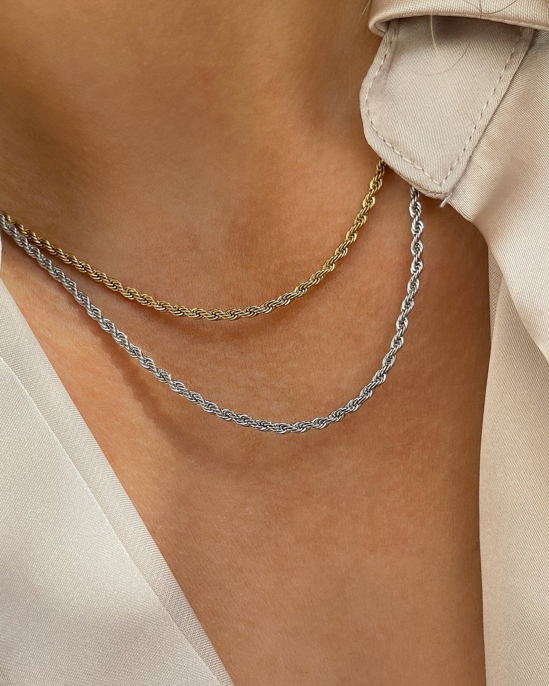 Gedrehte Edelstahl Kette in gold und silber, getragen mit weißer Bluse. Wasserfest und hypoallergen.