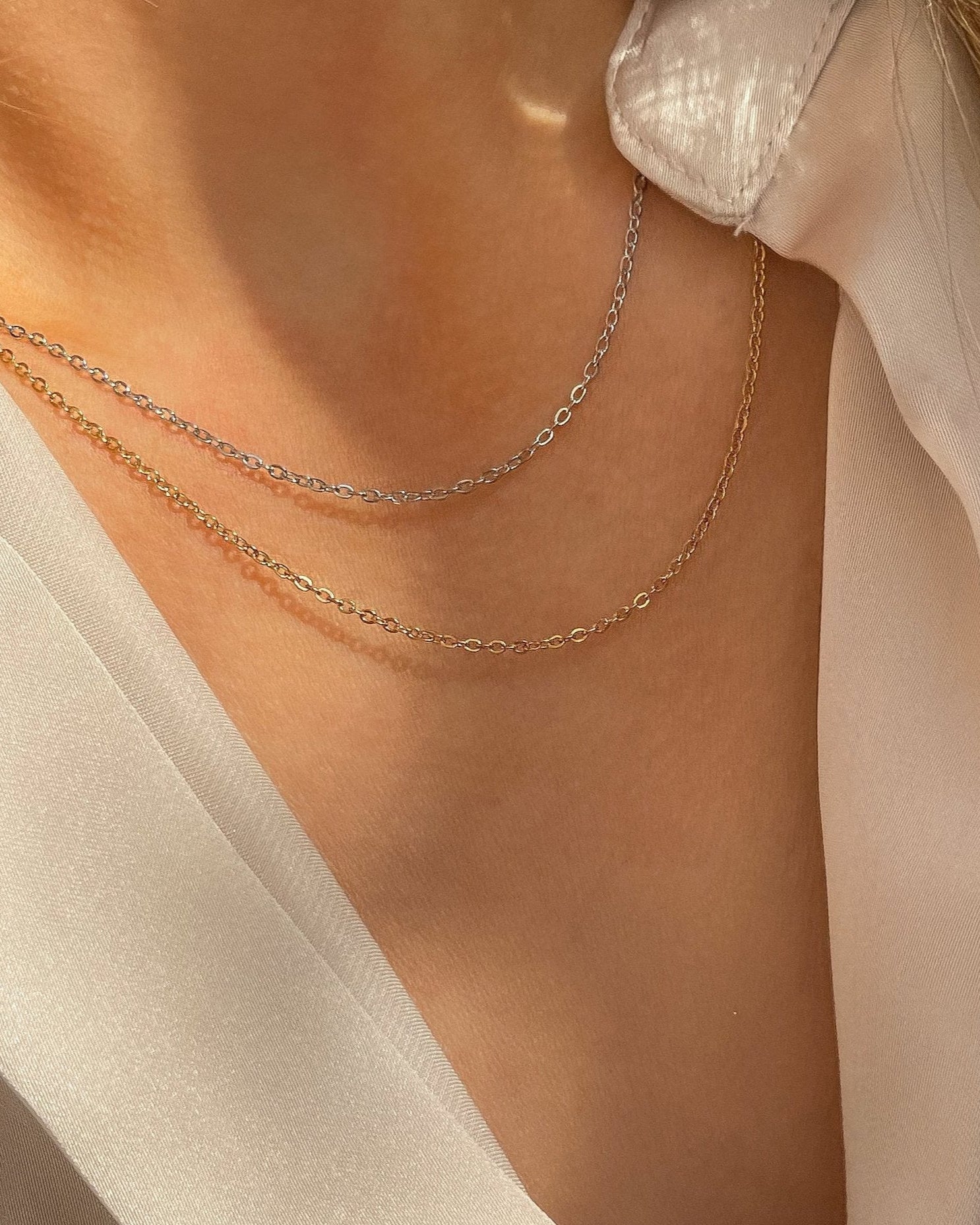 Simple, filigrane Edelstahl Halskette, getragen mit beiger Bluse. Wasserfest und hypoallergen.