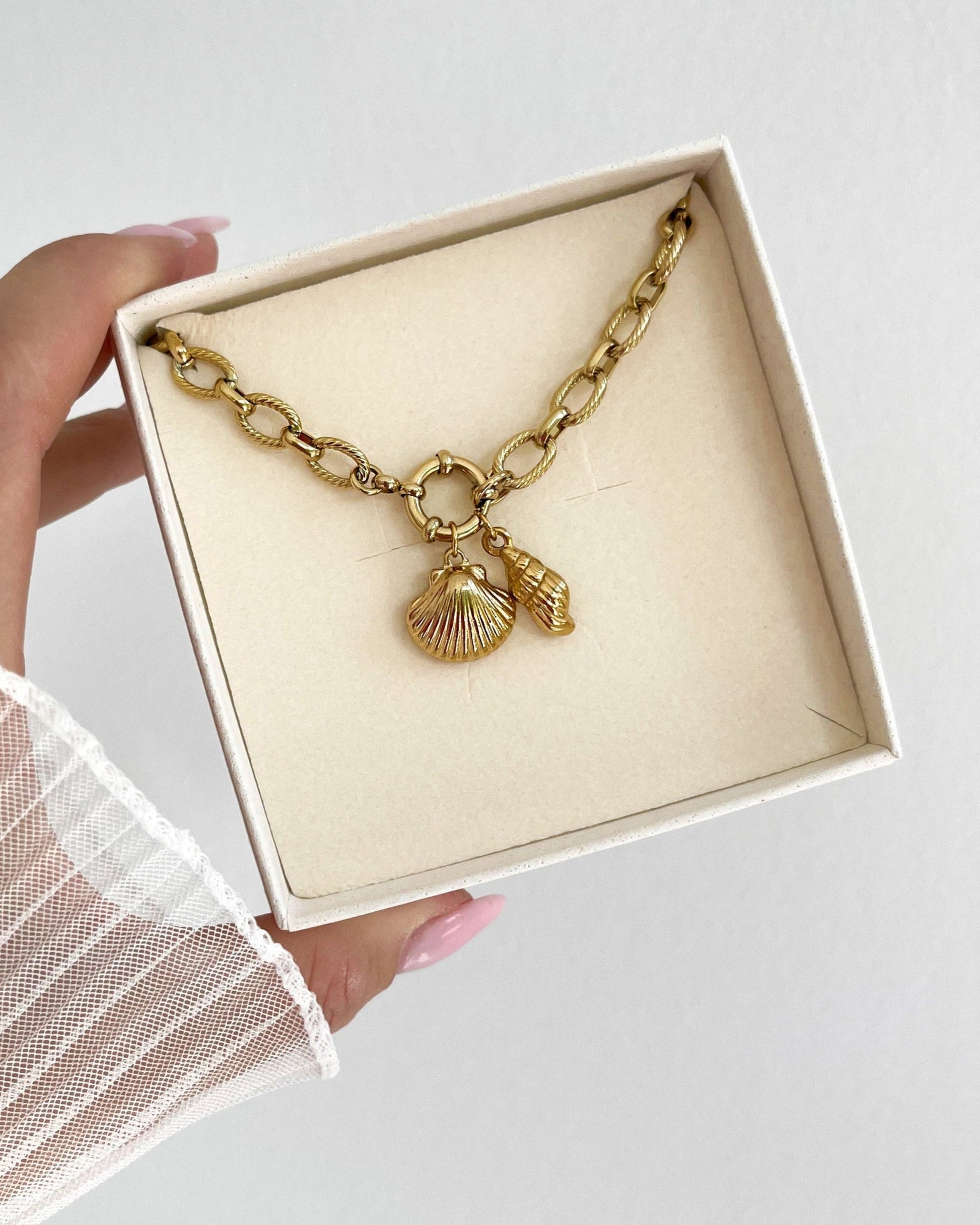 Wasserfester Edelstahl Charm in Muschel Form an goldenem Armband