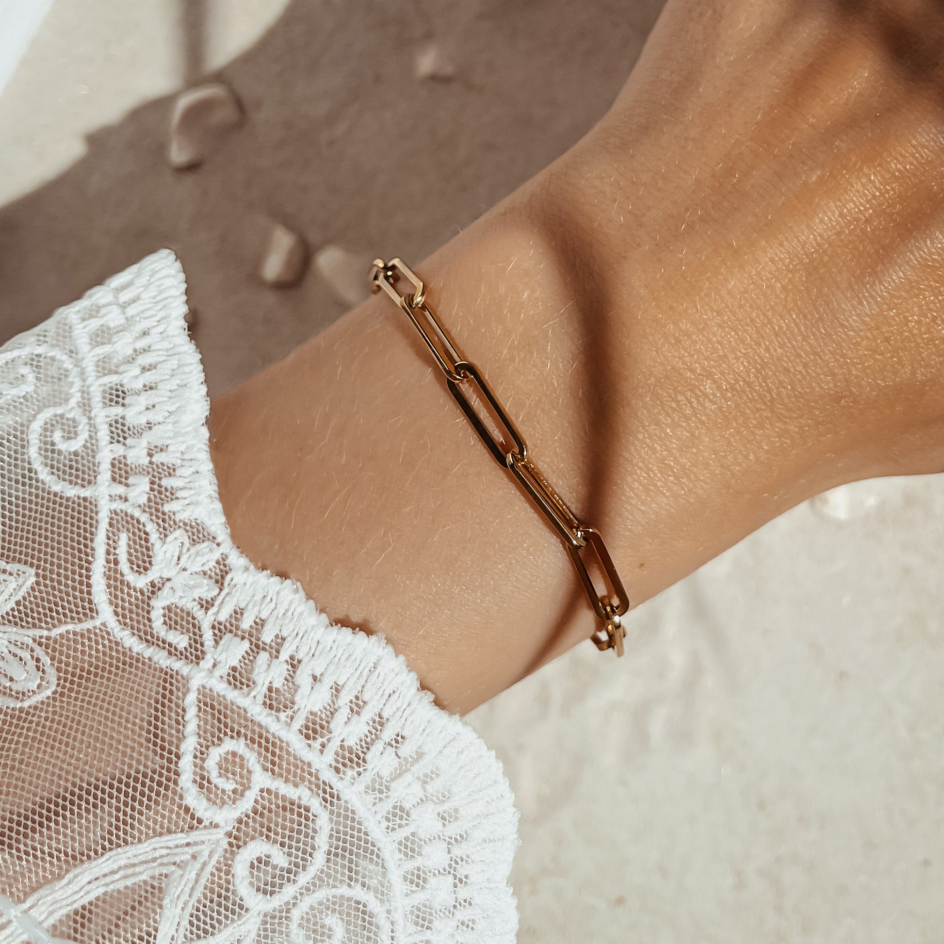 Grobgliederiges Edelstahl Armband in gold, getragen am Handgelenk.
