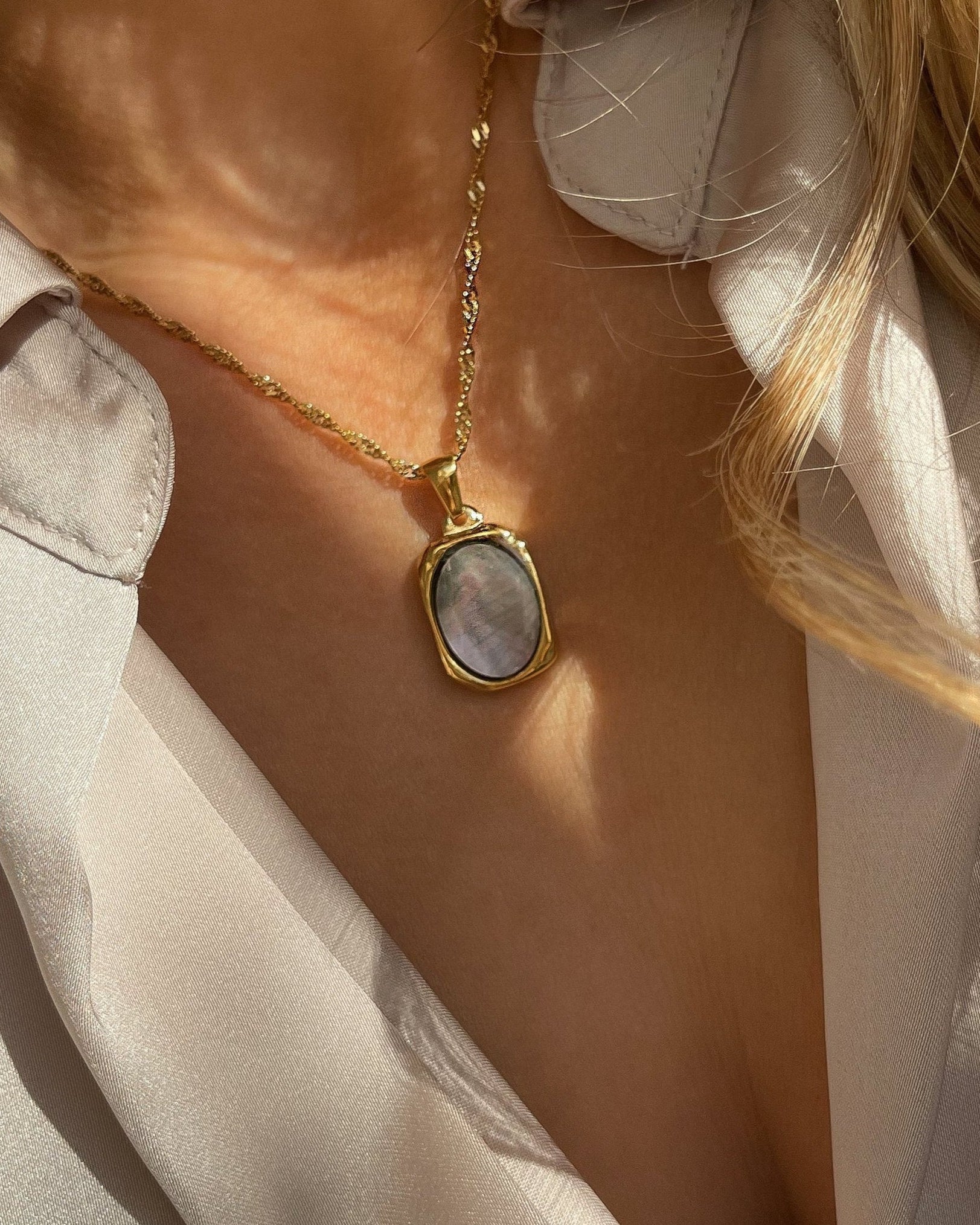 Vergoldete Edelstahlkette mit Muschelperllmutt Design, elegant, getragen mit beigefarbener Bluse. Wasserfest und hypoallergen.