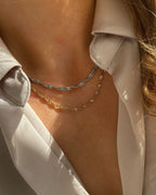 In sich gedrehte Edelstahl Kette mit 18k Vergoldung. Getragen mit einer beigefarbenen Bluse. Wasserfest und hypoallergen.