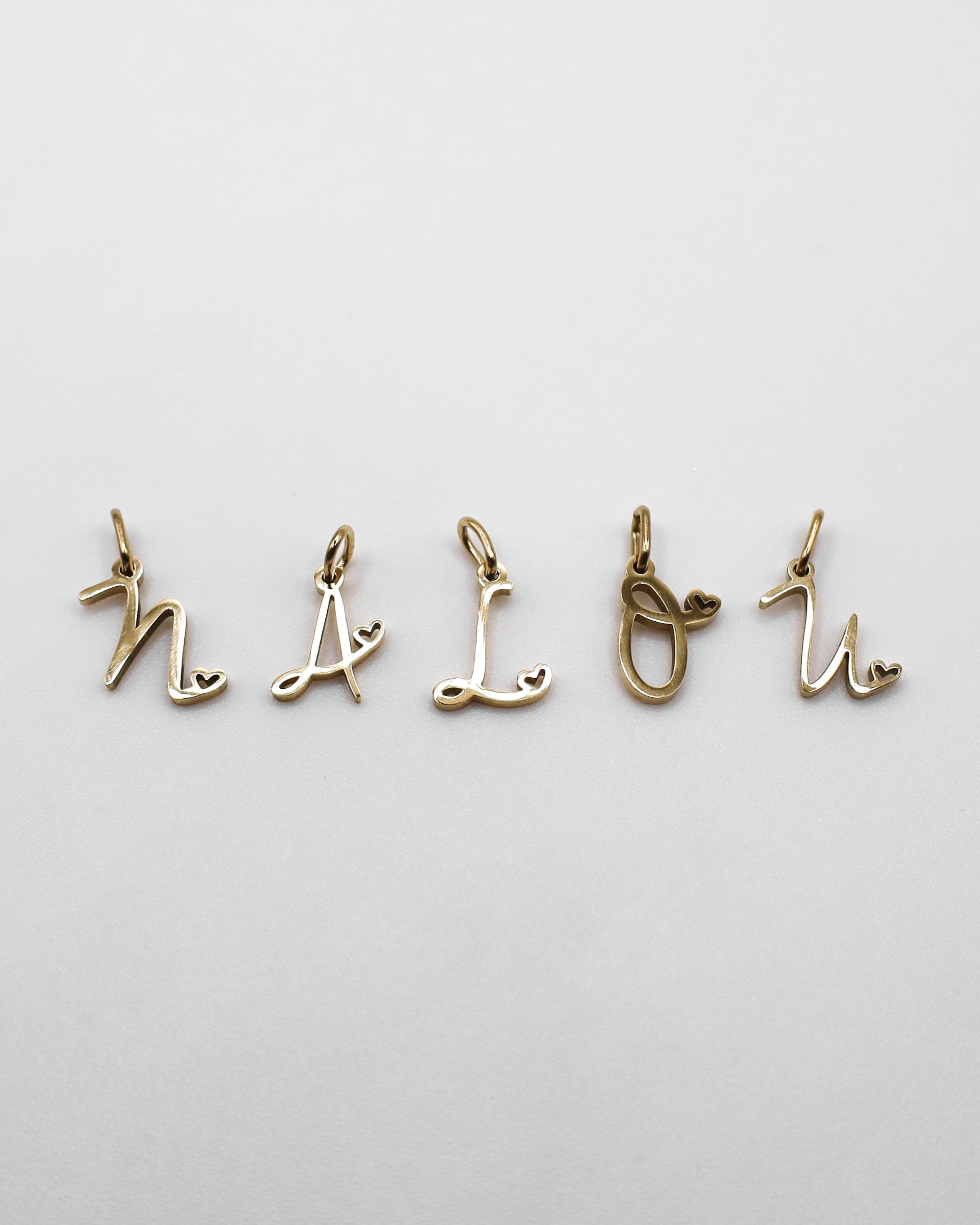 Verspielte Buchstaben Anhänger in gold. 