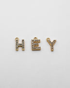 Goldene Buchstaben Anhänger mit Zirkonia Steinen.