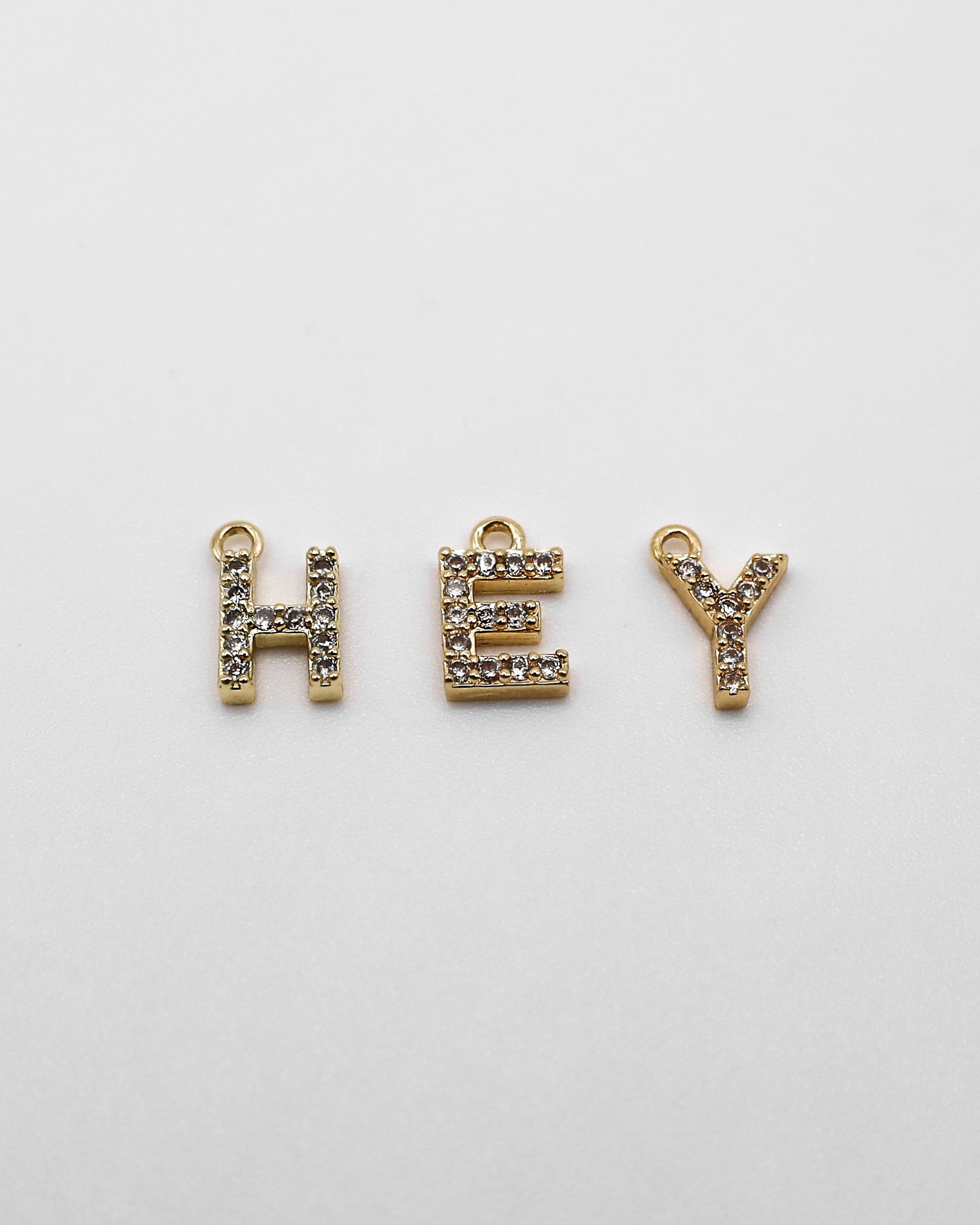 Goldene Buchstaben Anhänger mit Zirkonia Steinen.