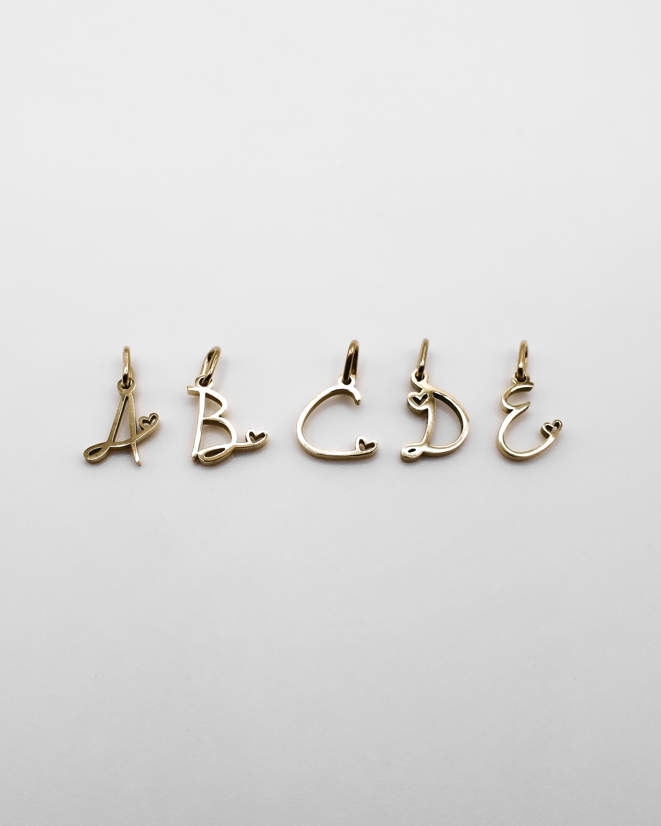 Verspielte Buchstaben Anhänger in gold. Buchstabe A, B, C, D, E