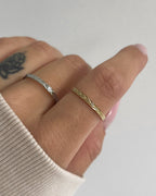 Verstellbarer, feiner Edelstahlring mit dezentem Muster., getragen am Finger.