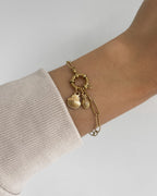 Edelstahl Charm in Muschelform an goldenem Armband. Wasserfest und hypoallergen.