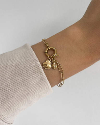 Edelstahl Charm in Muschelform an goldenem Armband. Wasserfest und hypoallergen.