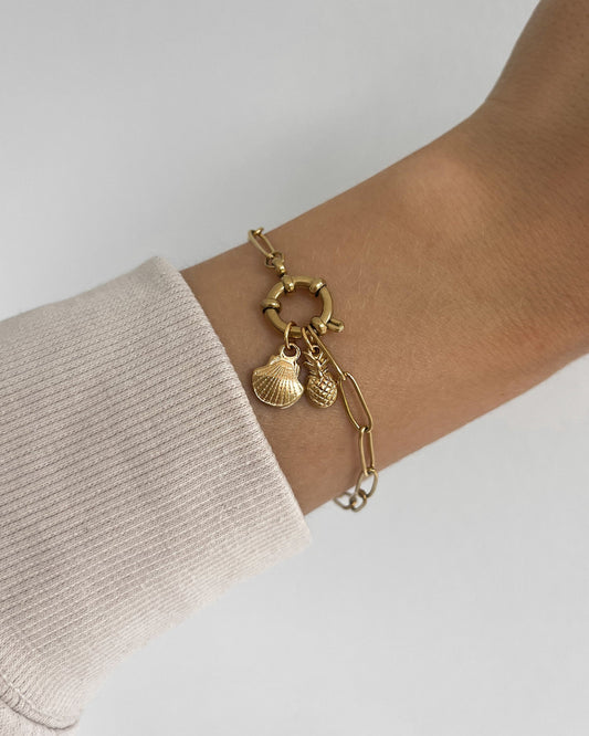 Edelstahl Charm in Muschelform an goldenem Armband. Wasserfest und hypoallergen.