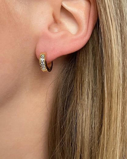 Wasserfeste Edelstahl Ohrringe mit Zirkonia Steinen in  gold, getragen am Ohr.