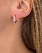 Wasserfeste Edelstahl Hoops mit Zirkonia Steinen besetzt in silber, getragen am Ohr.