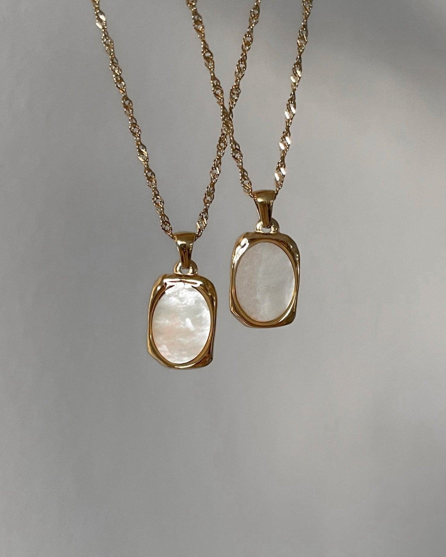 Goldene Halskette mit Ovalem Anhänger aus weißer Muschelperle.
