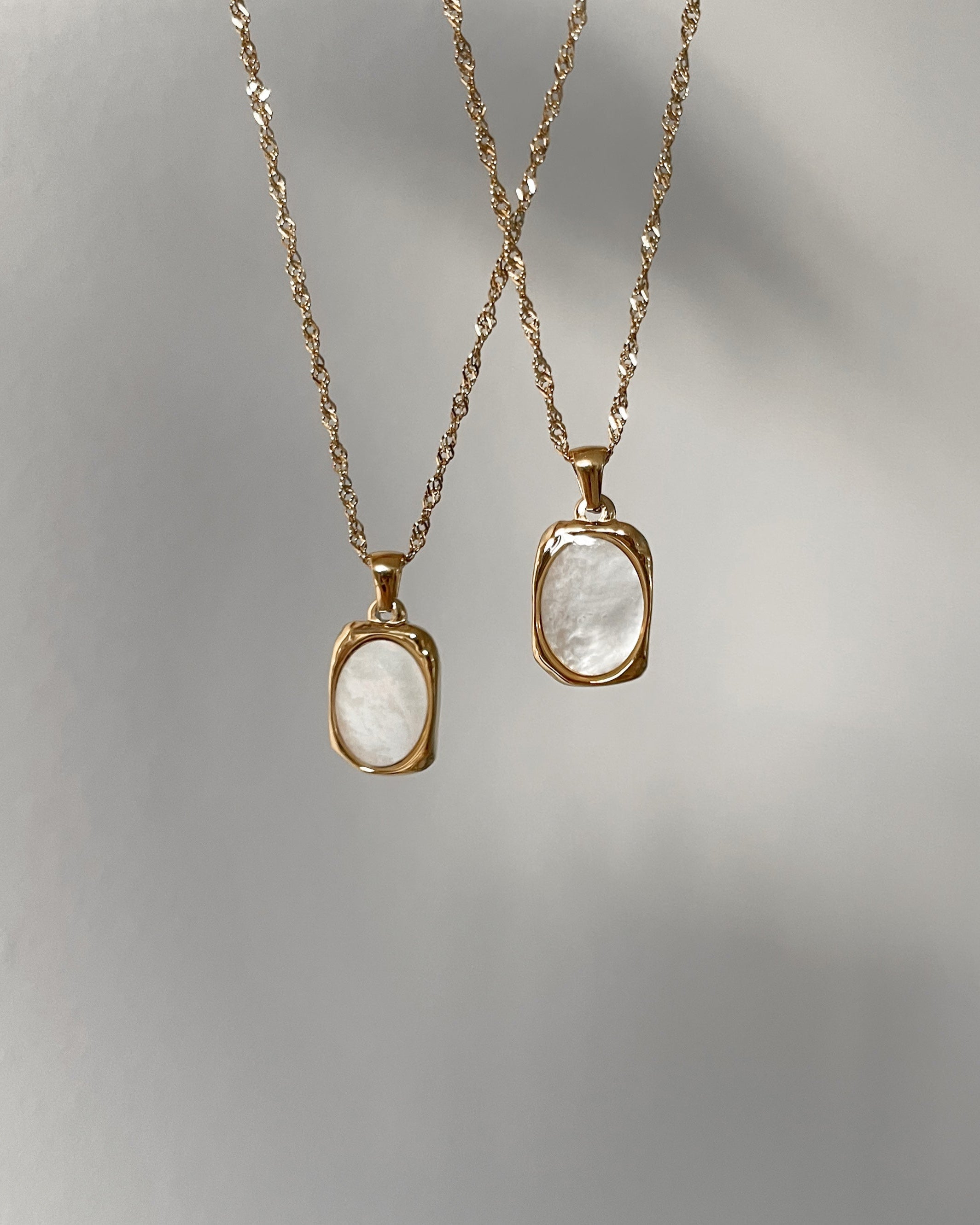Goldene Halskette mit Ovalem Anhänger aus weißer Muschelperle.