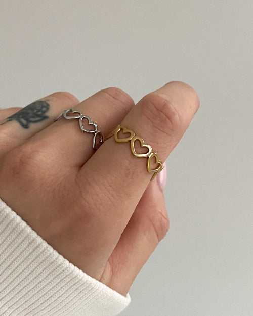 Wasserfester Edelstahlring, verstellbar mit aneinandergereihten Herzen, getragen am Finger.