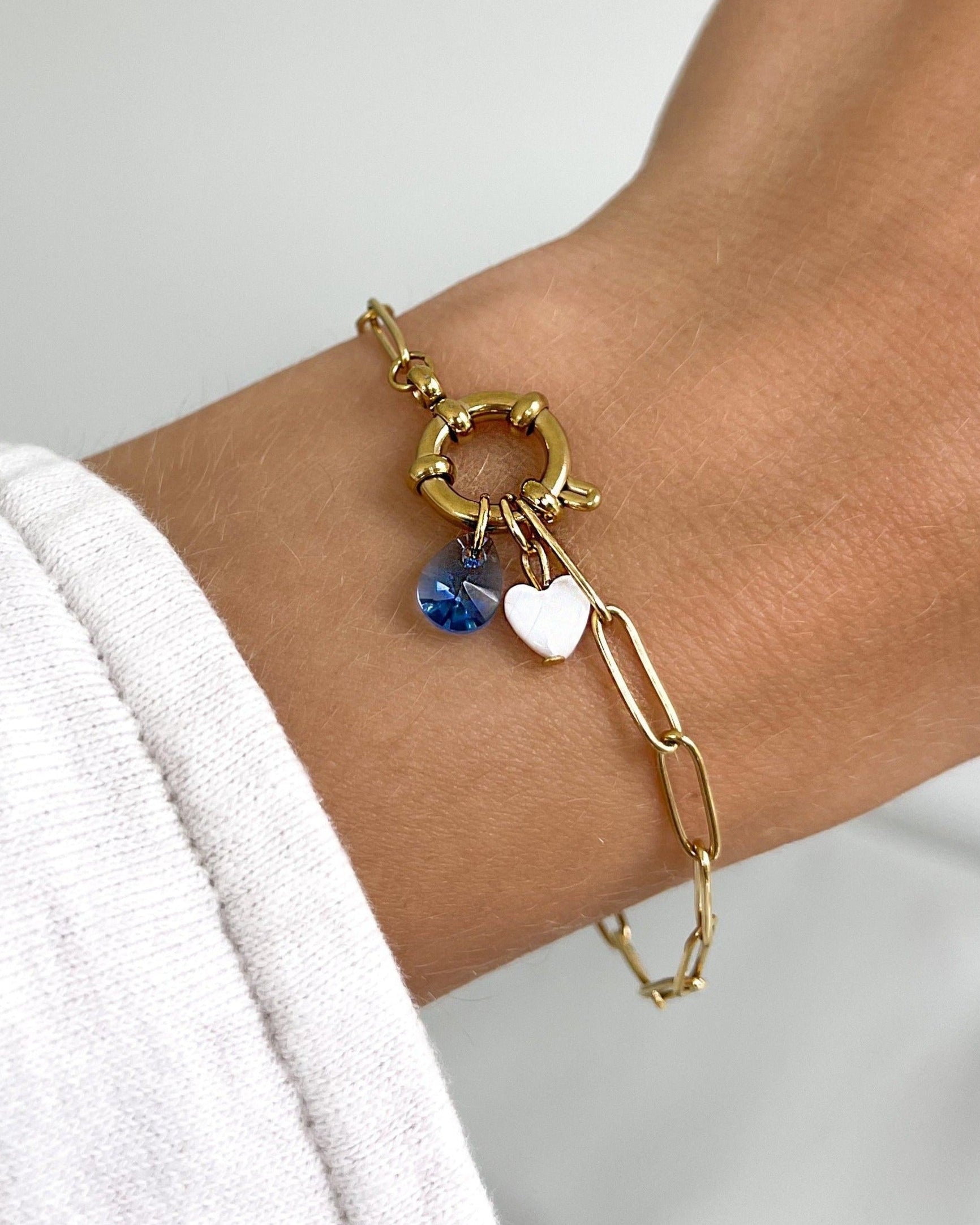 Geschliffener Glas Tropfen in türkis an goldenem Armband.