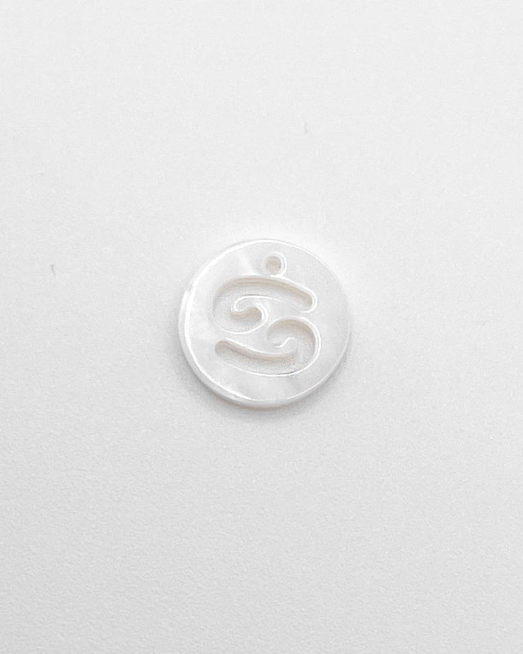 Weißer Charm mit ausgestanztem Sternzeichen Design.
