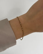 Feines, wasserfestes Edelstahl Armband mit gedrehtem Design, getragen am Handgelenk.