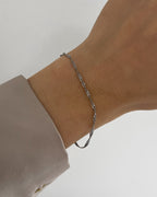 Feines, wasserfestes Edelstahl Armband mit gedrehtem Design, getragen am Handgelenk in silber.
