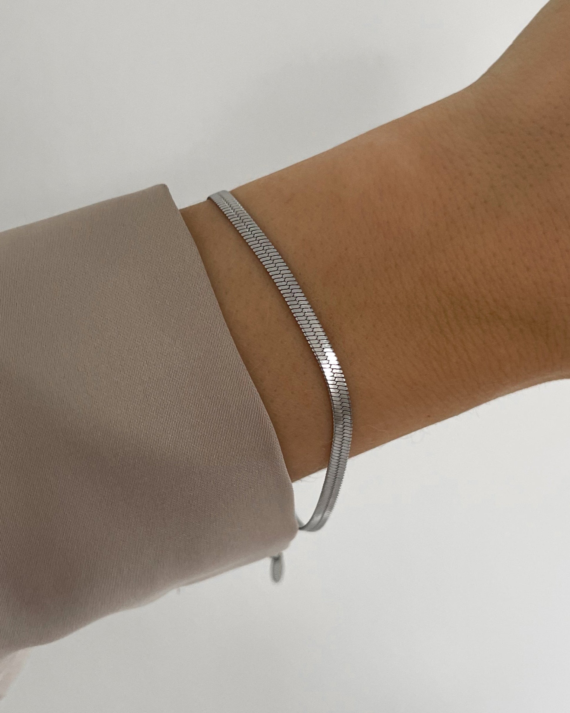 Feines, wasserfestes Edelstahl Armband in Schlangen Optik, getragen am Handgelenk.