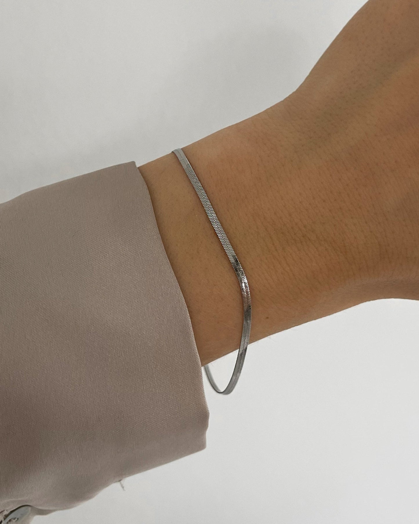 Feines, wasserfestes Edelstahl Armband in Schlangen Optik, getragen am Handgelenk.