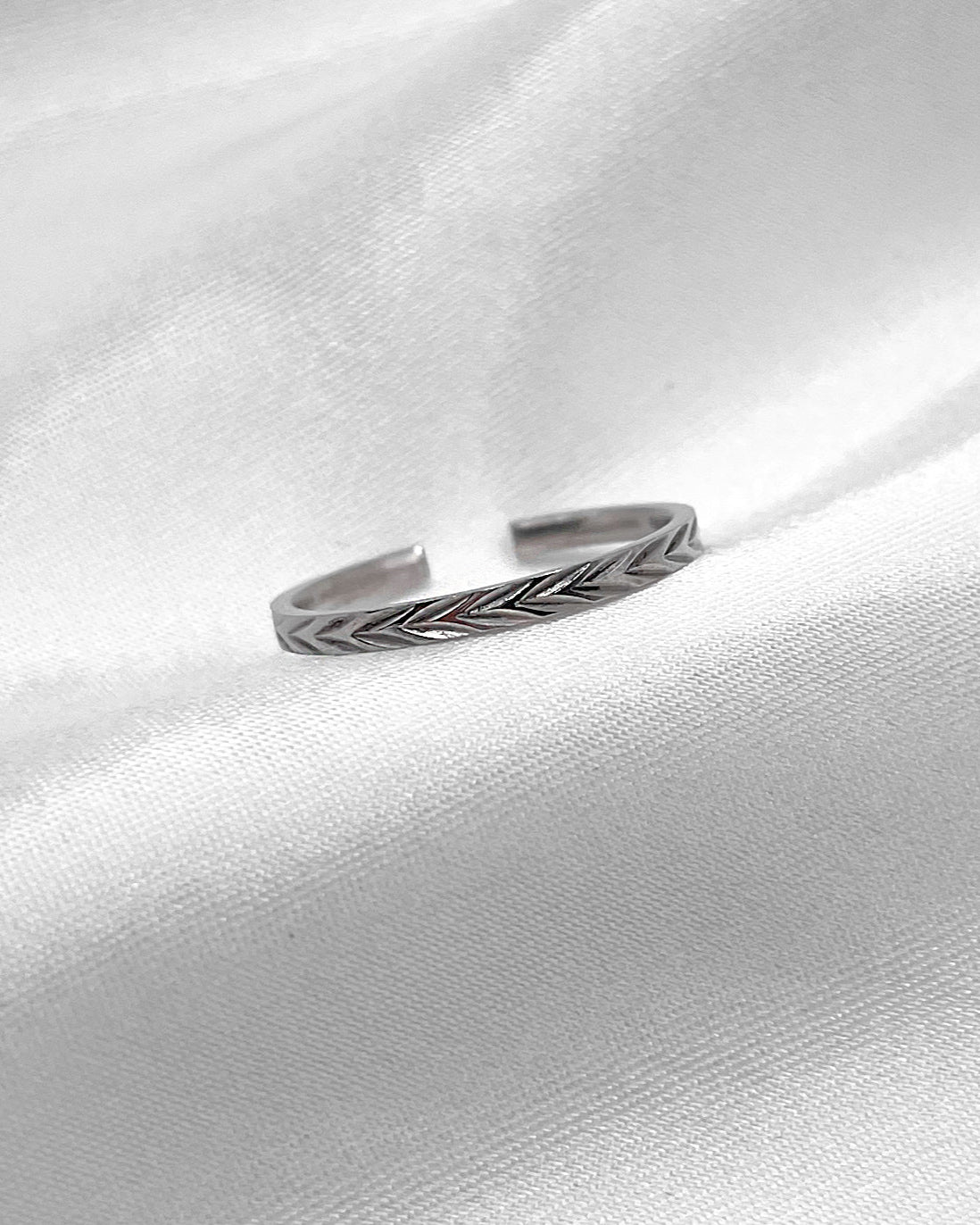 Verstellbarer, feiner Edelstahlring mit dezentem Muster in silber.