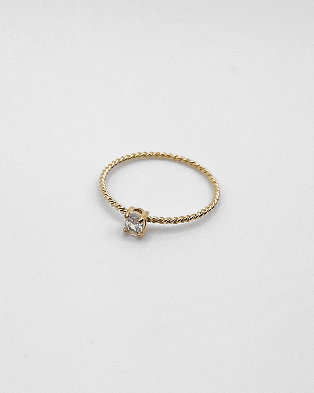Goldener Ring mit einem feinen gedrehten Design und einem kleinen runden Zirkonia.
