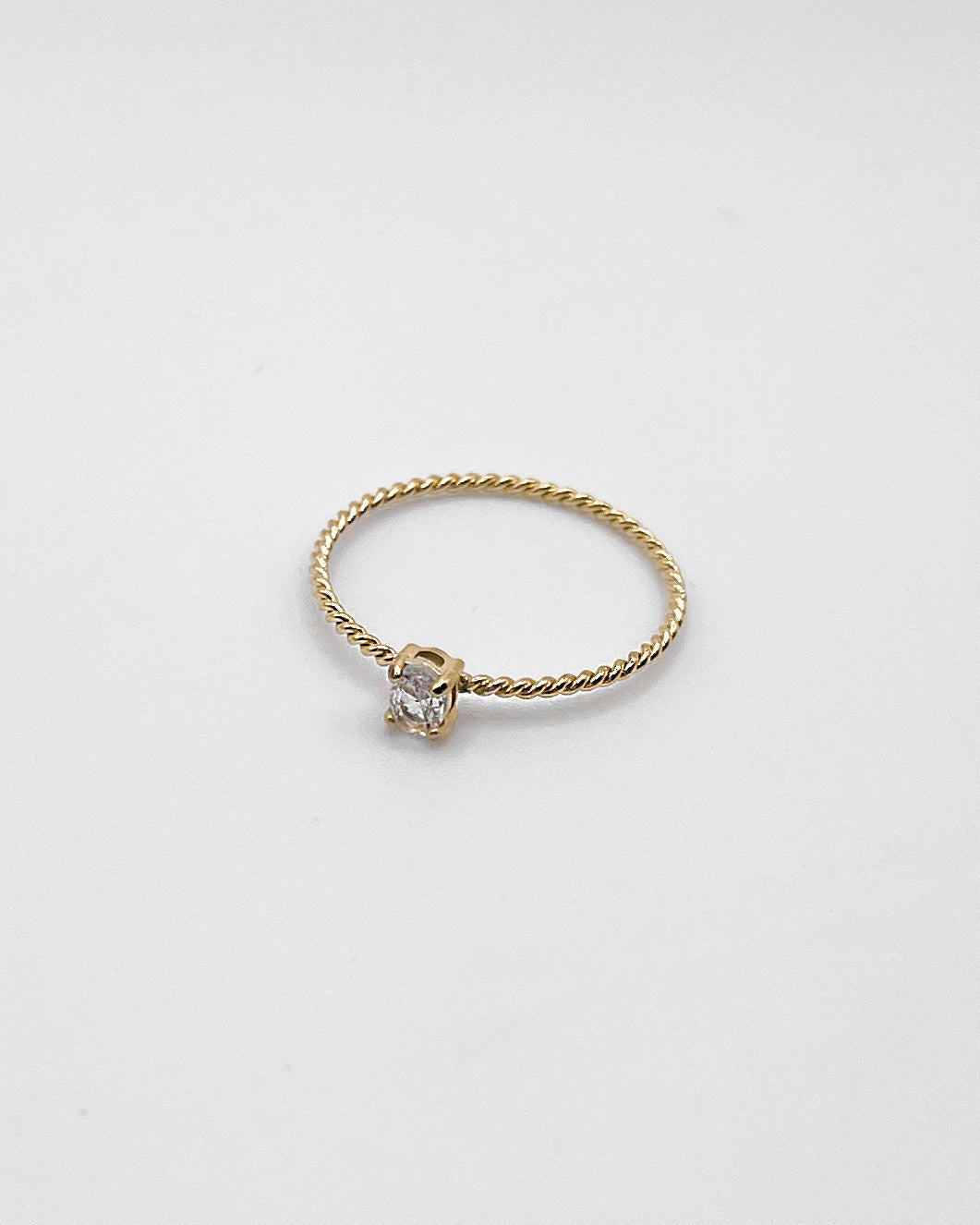 Goldener Ring mit einem feinen gedrehten Design und einem kleinen runden Zirkonia.