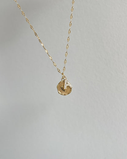 Runder Edelstahl Charm mit Herz in der Mitte an einer filigranen Kette mit Buchstaben Charm. Wasserfest und hypoallergen.