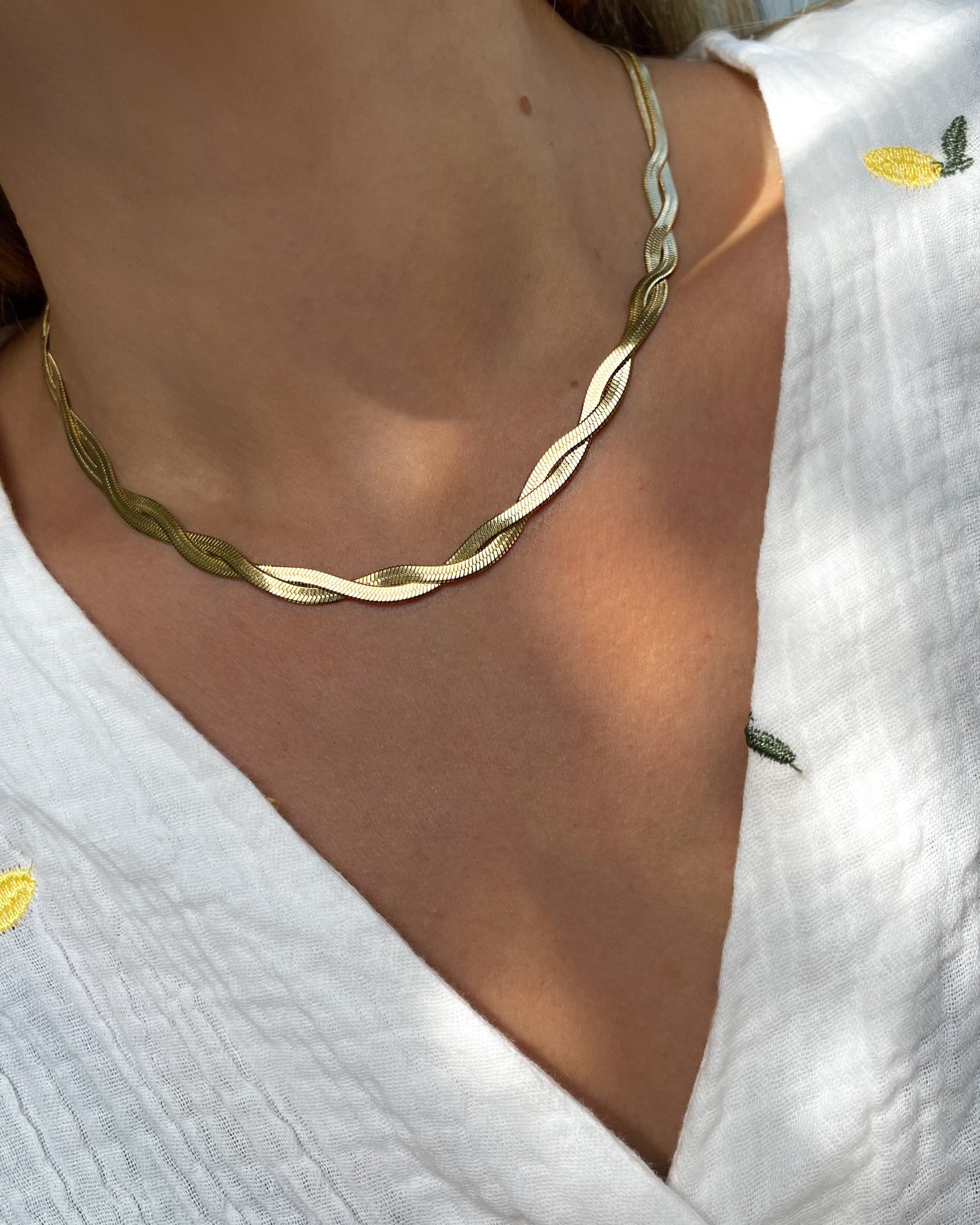 Vergoldete Edelstahl Kette in gedrehtem Schlangen Design, getragen zu einer weißen Bluse. Wasserfest und hypoallergen.