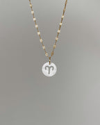 Weißer Charm mit ausgestanztem Sternzeichen Design.