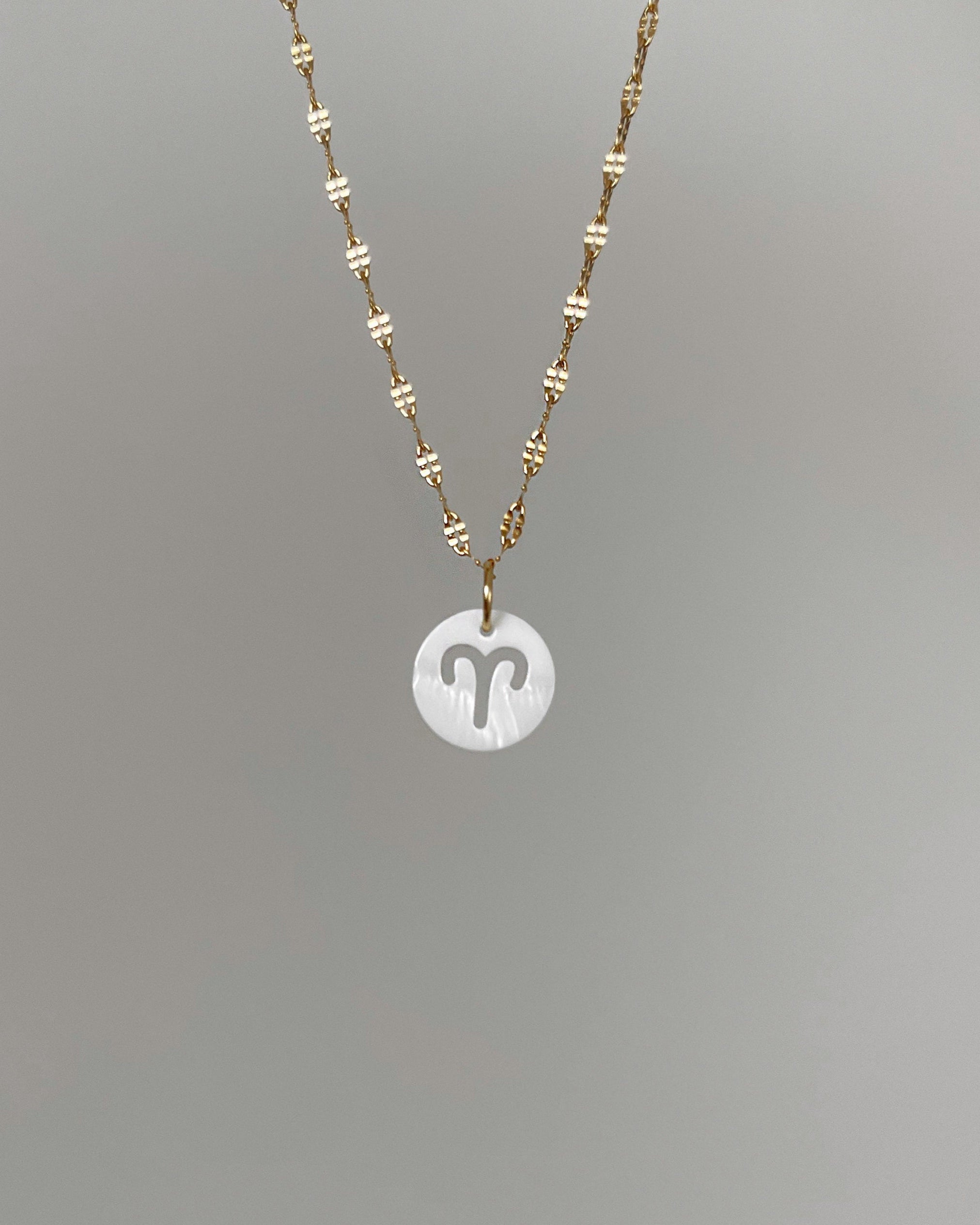 Weißer Charm mit ausgestanztem Sternzeichen Design.
