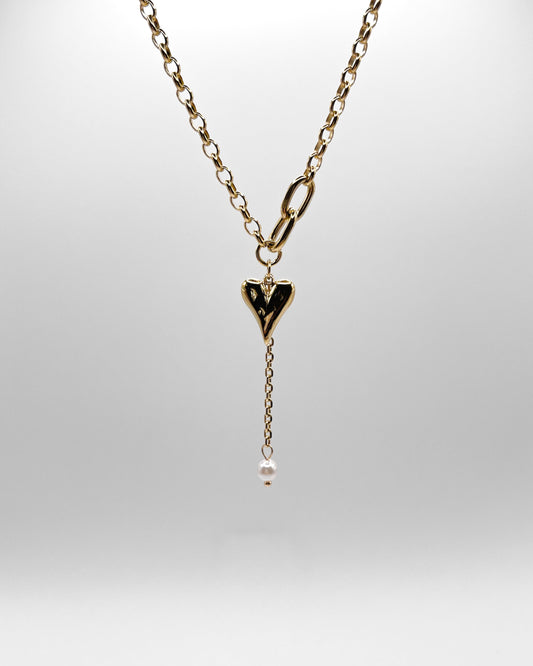 Verspielte goldene Kette mit Herz und Perle.