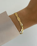 Wasserfestes Edelstahl Armband in gedrehtem Schlangendesign, getragen am Handgelenk.