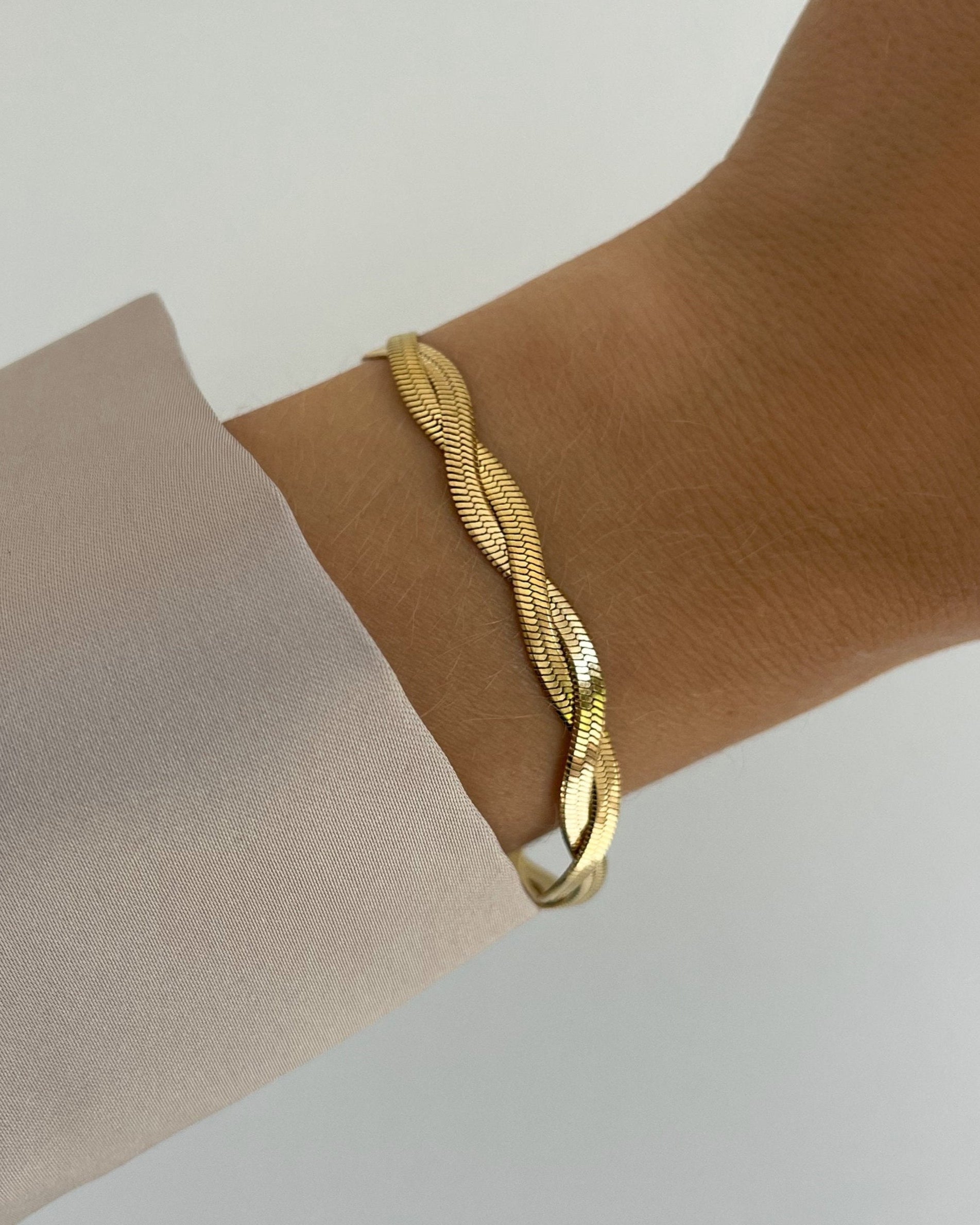 Wasserfestes Edelstahl Armband in gedrehtem Schlangendesign, getragen am Handgelenk.