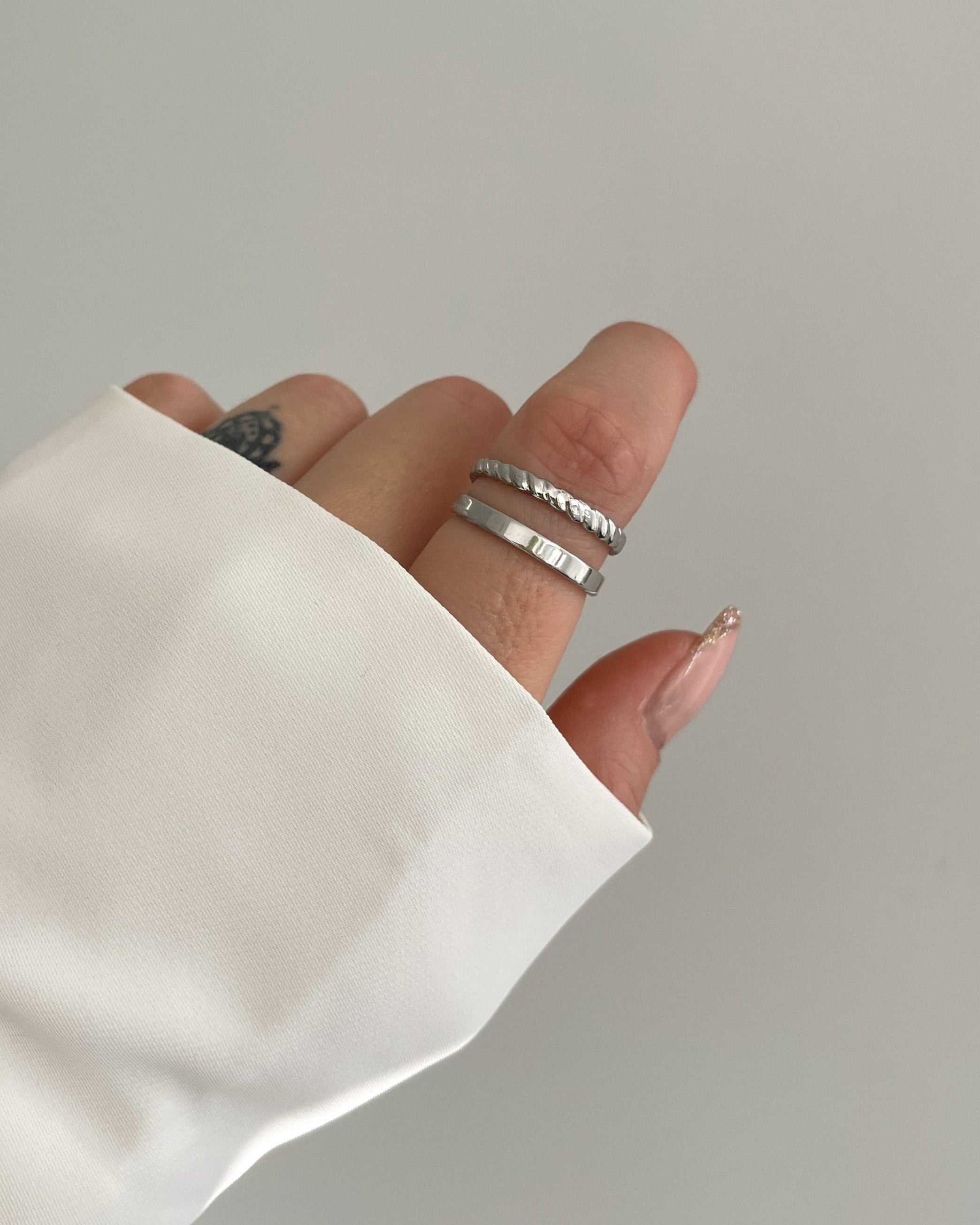 Doppellagiger, verstellbarer wasserfester Edelstahlring in silber, getragen am Finger.