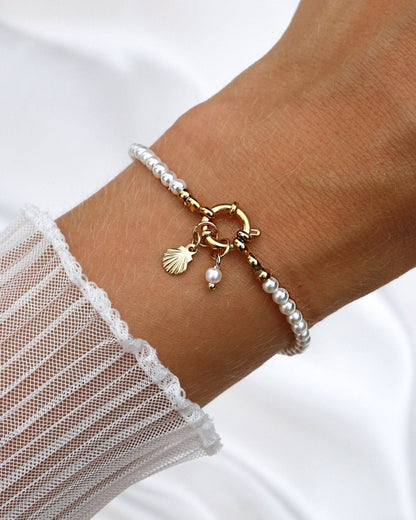 Wasserfester Edelstahl Charm in Muschelform an einem Perlenarmband.