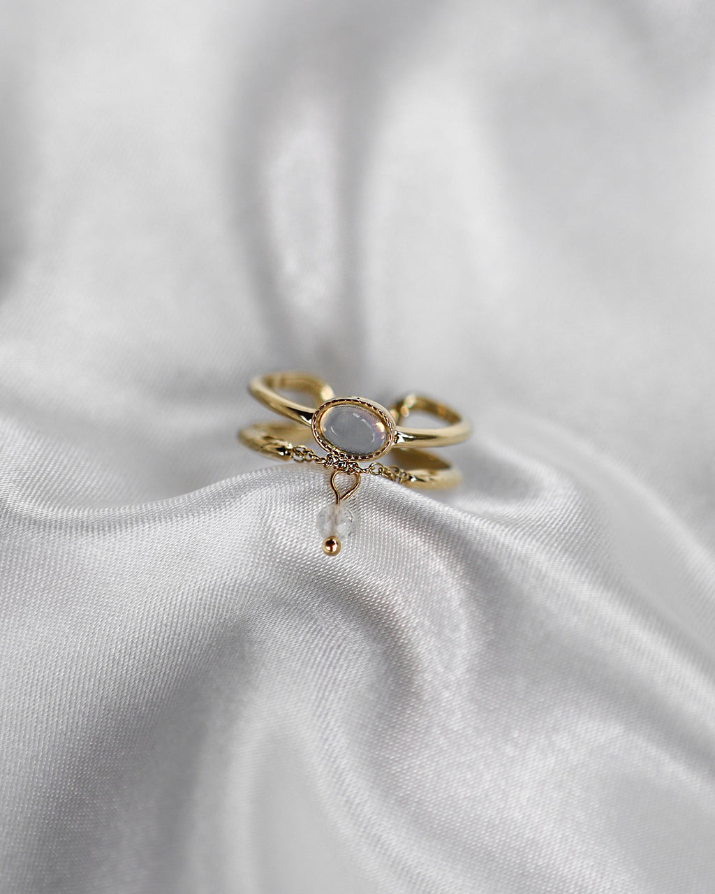 Doppellagiger Ring mit schimmerndem Detail und Kettendesign in gold.