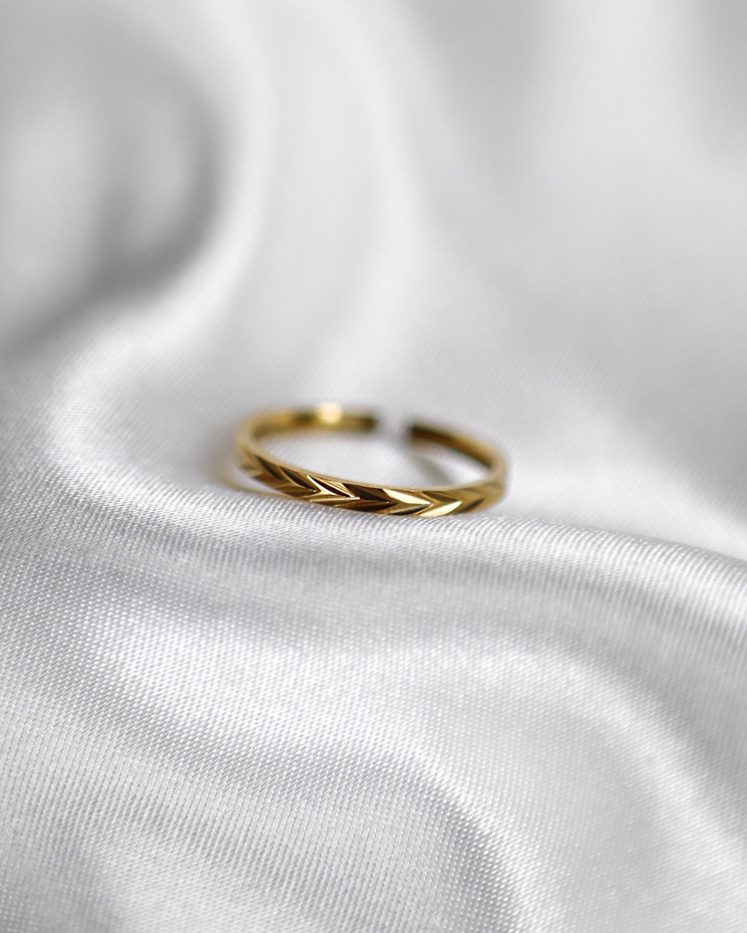 Verstellbarer, feiner Edelstahlring mit dezentem Muster in gold.