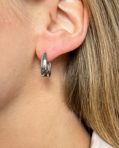 Ovale wasserfeste Edelstahl Hoops in silber, getragen am Ohr.