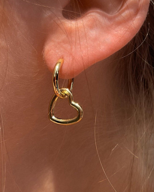 Wasserfeste Basic Edelstahl Kreolen mit abnehmbaren Herz Anhänger in gold, getragen am Ohr.